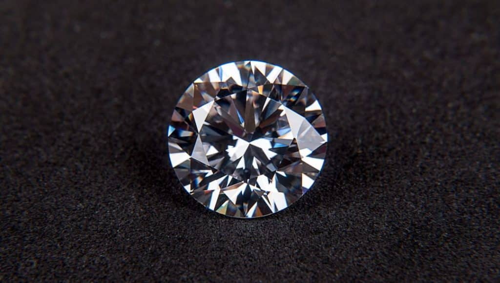 A round cut diamond on the dark surface