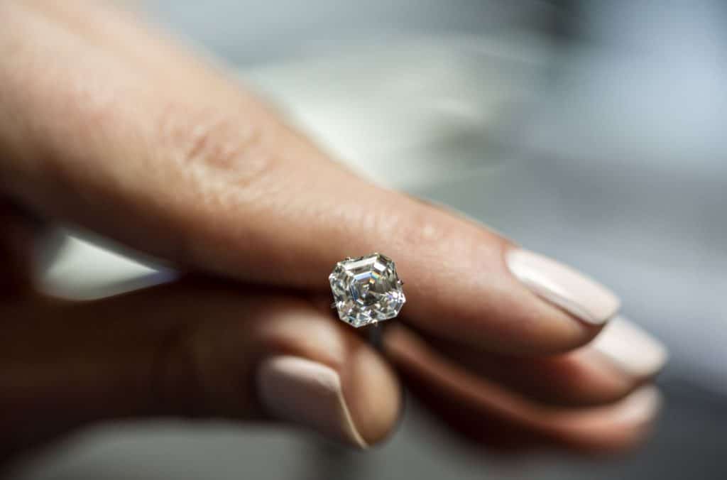 A person holding a diamond between fingers